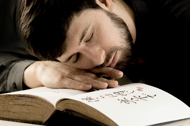 本を読みながら眠る男性